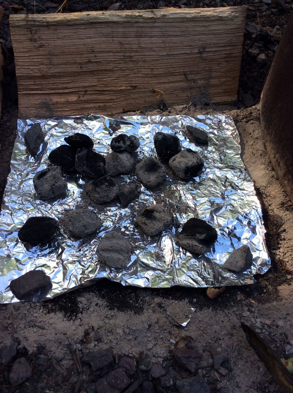 More coals are added to the location to where the lid stand was located. Add 10-12 hot coals.