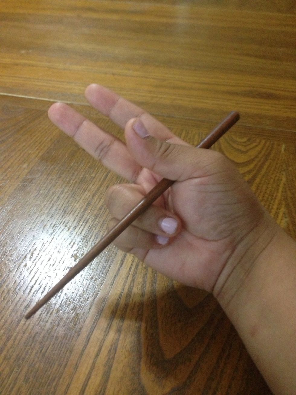 Most people would say to start off holding it like a pencil, but I found it difficult to use it that way.\ud83d\ude05 I suggest to tuck in your last to fingers underneath the chopstick first.