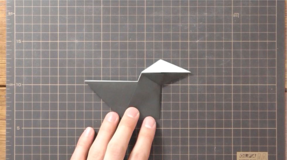 Mountain fold back the right side on center crease. Swivel fold upper and lower points to the right to form crow\u2019s beak.