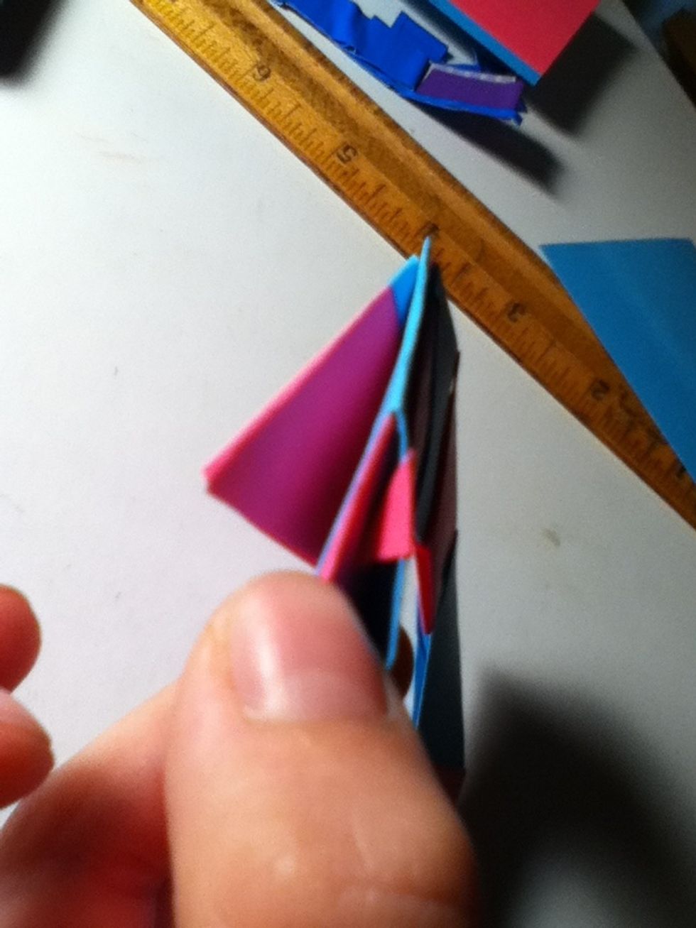 Move both the other papers to the side and fold tip into