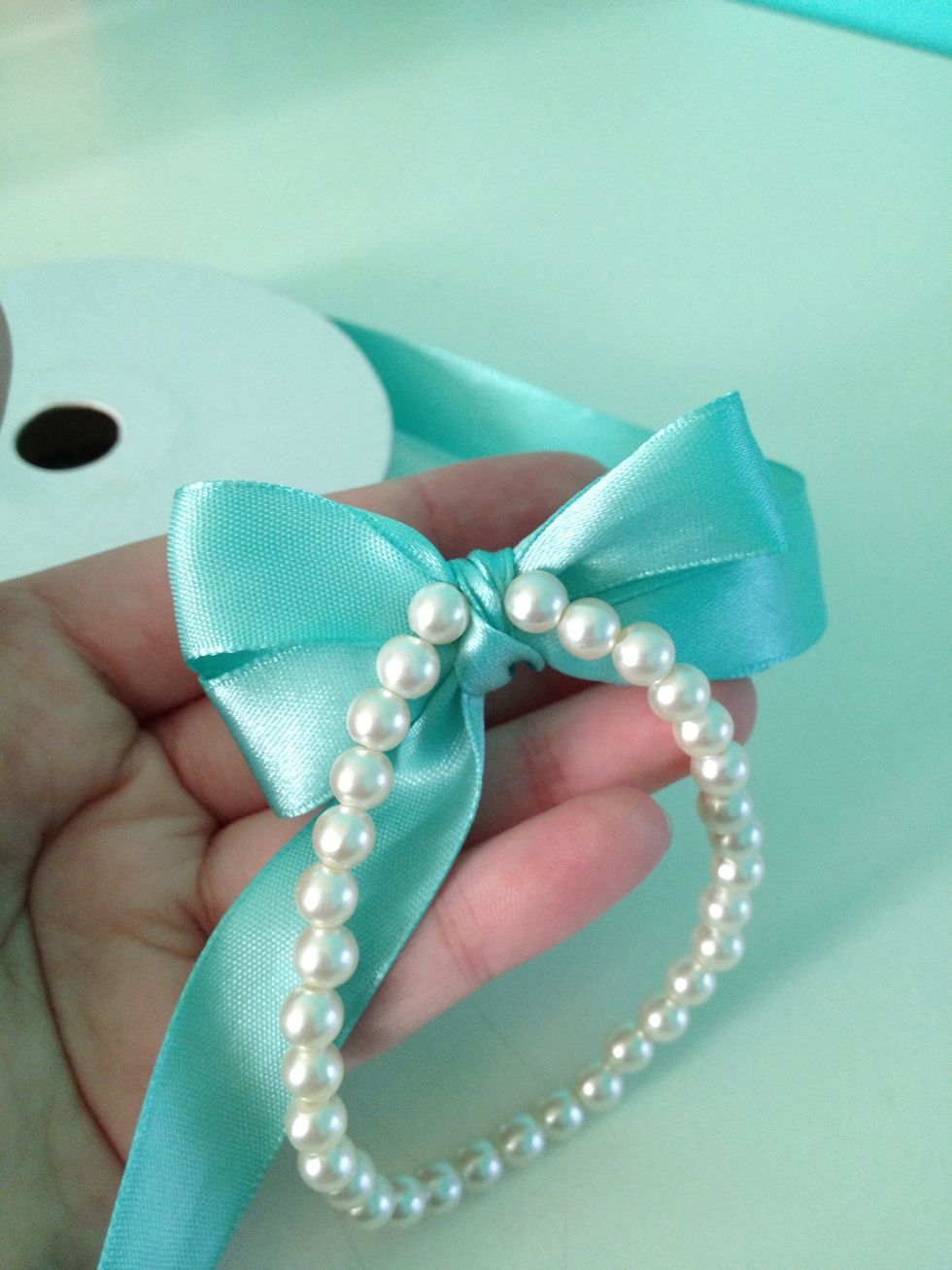 Move the bracelet so that it is at the back of the knot, (or in front of your hand).