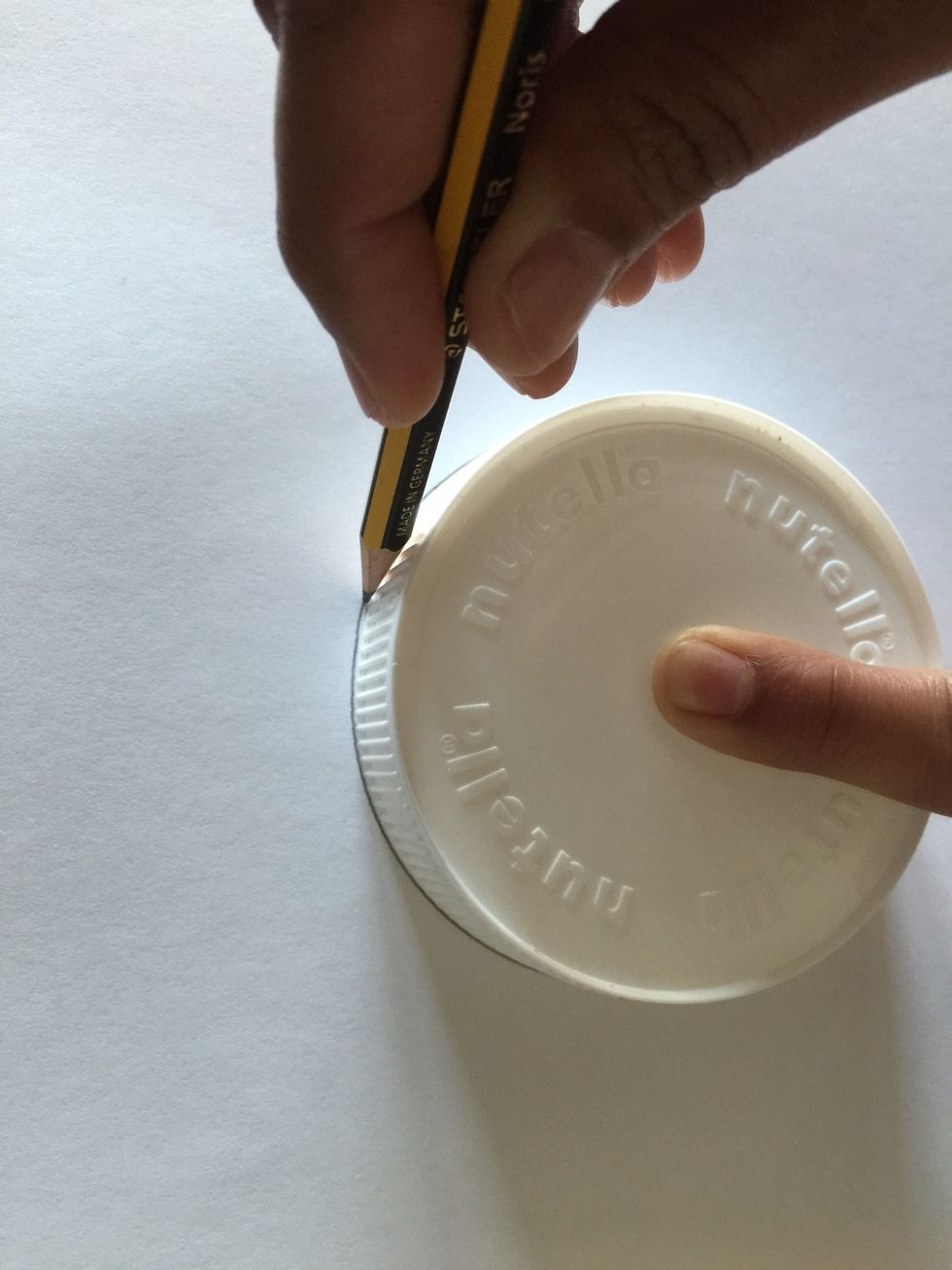 Move the pencil around the rim of the lid.