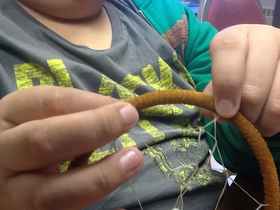Move the sinew Down the leather about 2 inches.  Tie another knot.  Than repeat all around the ring.