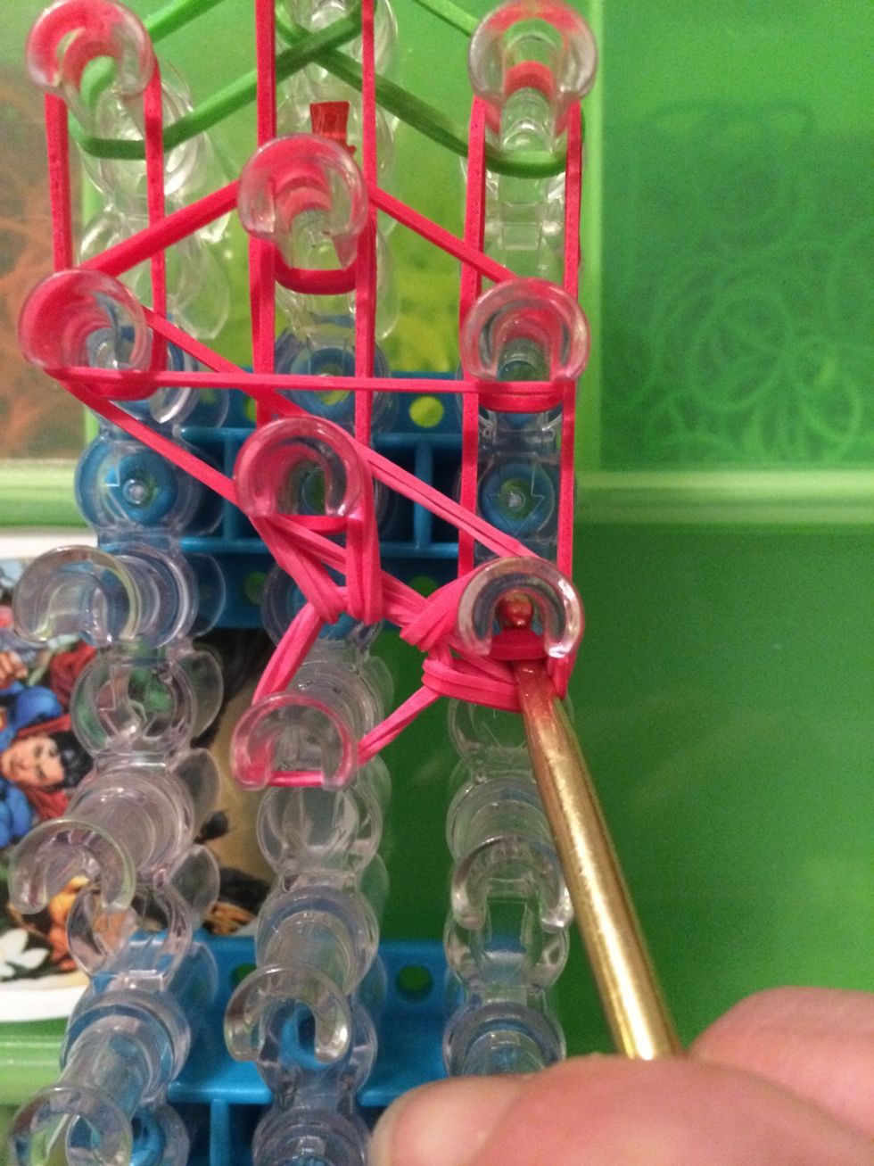 Move them to the right side. Reach in the peg and grab the 2 bands. Pull those bands forward onto to the next peg.
