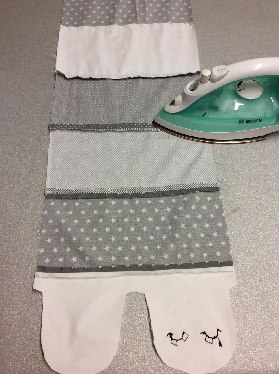 N\u00e4r alla delarna \u00e4r ihopsydda s\u00e5 pressa (stryk) med strykj\u00e4rnet is\u00e4r alla s\u00f6mmarna som bilden visar.