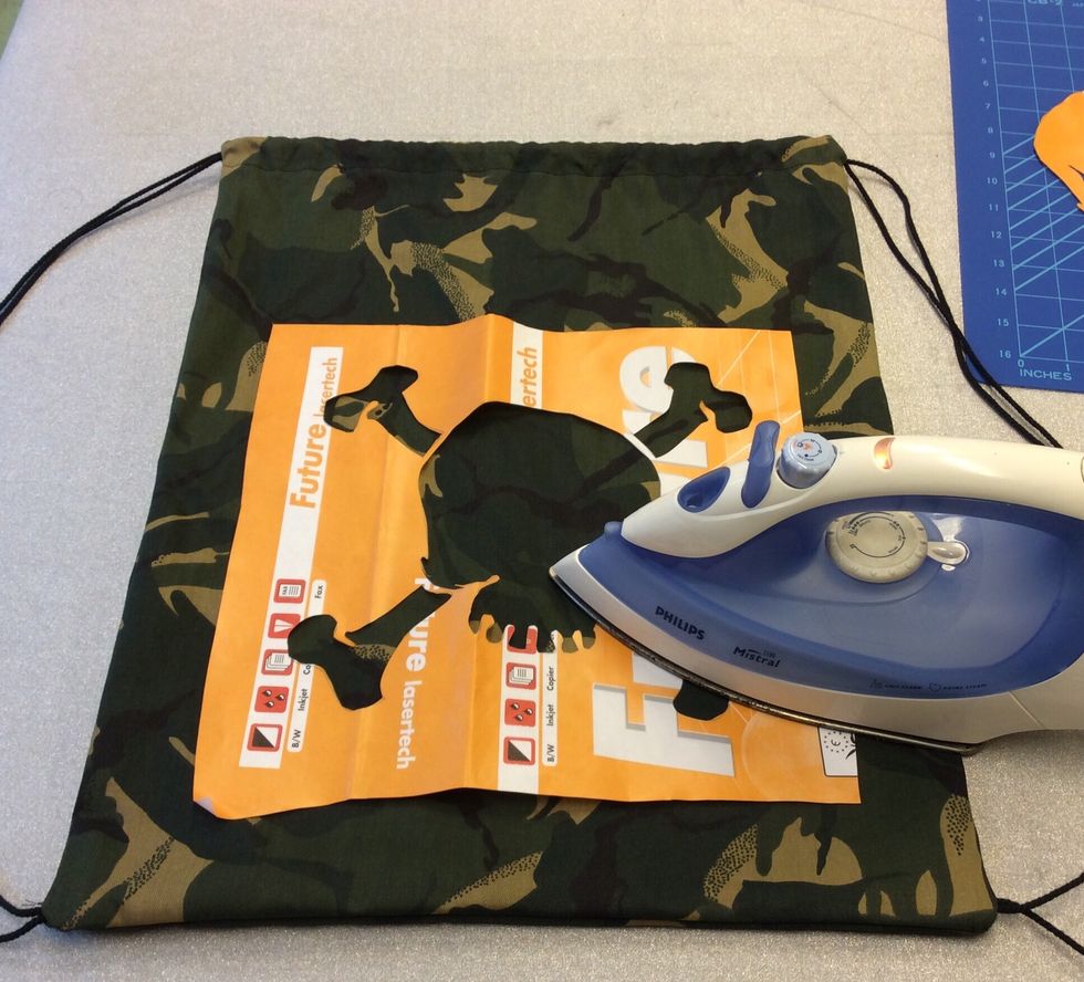 N\u00e4r allt \u00e4r utskuret placerar du f\u00f6rst det stora pappret, med gula sidan upp, p\u00e5 ditt tyg och stryker med medelvarmt strykj\u00e4rn tills det fastnat. T\u00e4nk p\u00e5 att det inte ska vara n\u00e5gon \u00e5nga p\u00e5)