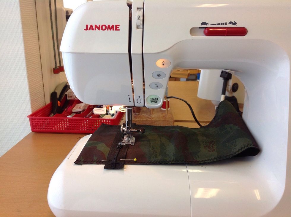 N\u00e4r du kommer till l\u00f6paren. Tryck p\u00e5 knappen med de tv\u00e5 trianglarna f\u00f6r att f\u00e5 n\u00e5len att stanna nere i tyget. Lyft sedan pressarfoten, dra f\u00f6rsiktigt f\u00f6rbi l\u00f6paren. S\u00e4nk pressarfoten och forts\u00e4tt sy.