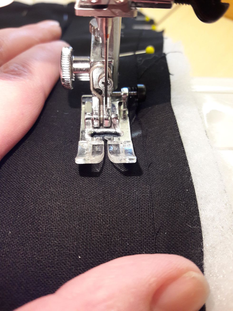 N\u00e4r du syr ska du f\u00f6lja kanten p\u00e5 framstycket, det \u00f6versta tyglagret. Kanten p\u00e5 det \u00f6versta tyglagret ska l\u00f6pa l\u00e4ngst med kanten p\u00e5 pressarfoten. D\u00e5 blir s\u00f6msm\u00e5nen j\u00e4mn runt om hela.