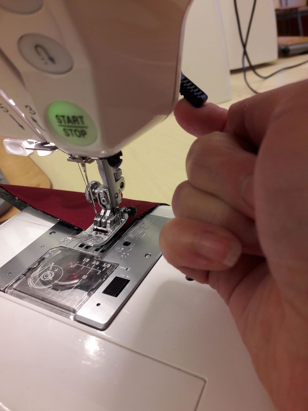 N\u00e4r du \u00e4r klar tar du loss tyget fr\u00e5n symaskinen genom att lyfta pressarfoten. Det g\u00f6r du genom att f\u00e4lla upp denna spak.