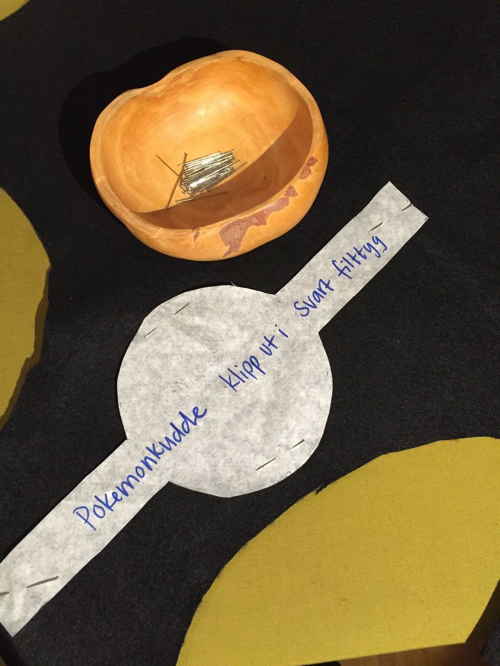 N\u00e5la fast den mellersta cirkeln med strecket p\u00e5 svart tyg. Klipp ut.