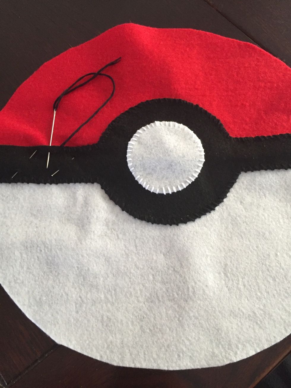 N\u00e5la fast den svarta delen mitt p\u00e5 den r\u00f6d-vita cirkeln. Sy fast den med F\u00d6RSTYGN eller KASTSTYGN. Best\u00e4m tillsammans med din l\u00e4rare.