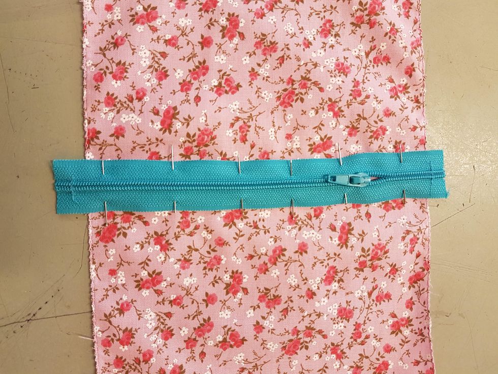 N\u00e5la fast dragkedjan \u00f6ver mittmarkeringen p\u00e5 r\u00e4tsidan av tyget. N\u00e5la t\u00e4tt.