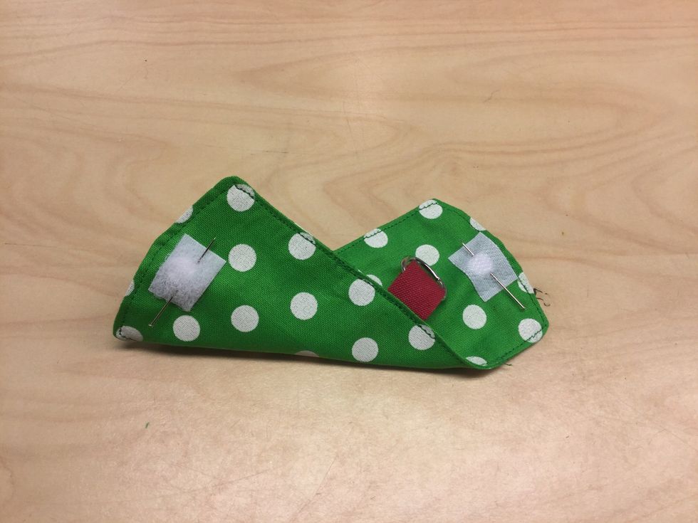 N\u00e5la fast kardborrebandets tv\u00e5 delar, en i var \u00e4nde och en p\u00e5 utsidan och den andra p\u00e5 insidan.