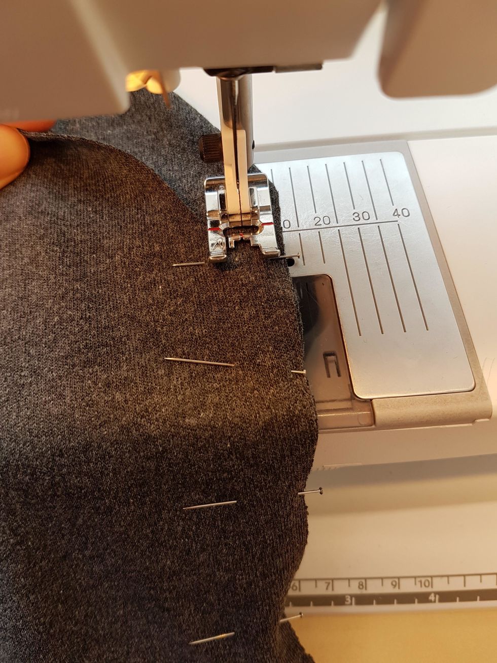N\u00e5la fast och sy fast fickorna med s\u00f6m nr 8. Sy med 1 cm s\u00f6msm\u00e5n, tyget f\u00f6ljer d\u00e5 10 strecket till h\u00f6ger om pressarfoten. Se till att ta bort n\u00e5larna s\u00e5 du inte r\u00e5kar sy \u00f6ver dem.