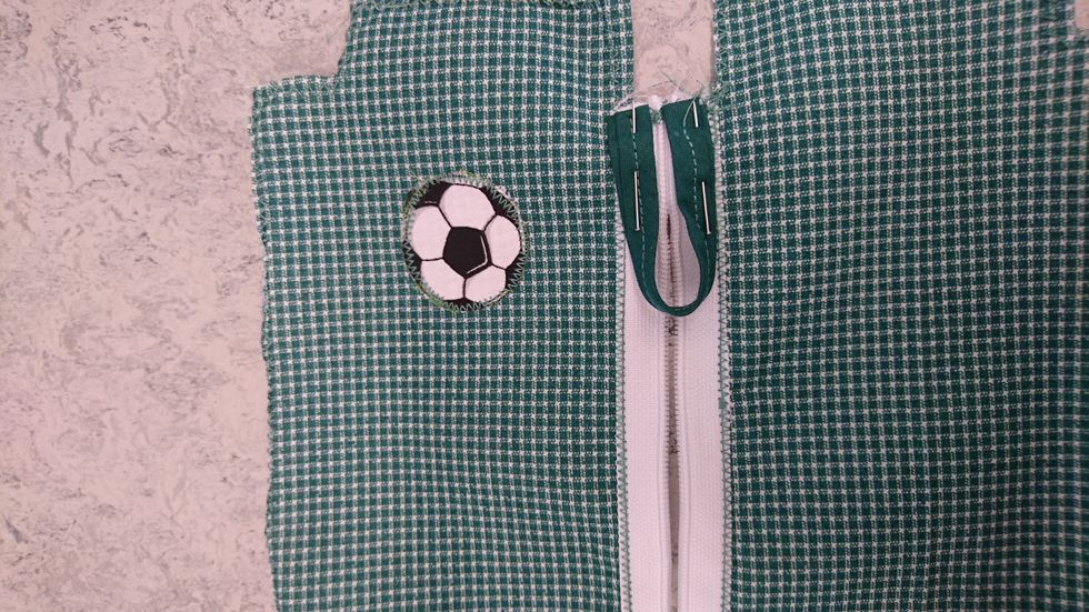 n\u00e5la fast p\u00e5 sidan om dragkedjan som bilden visar, sy fast med raks\u00f6m och ta bort n\u00e5larna.