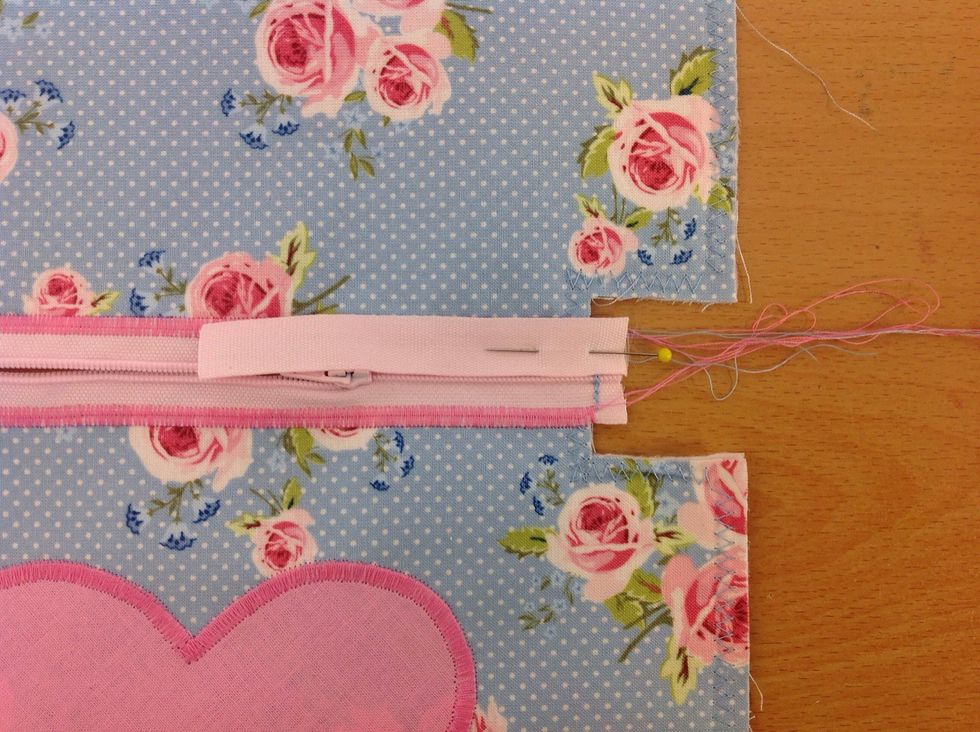 N\u00e5la fast \u00e4nden p\u00e5 ena sidan av dragkedjan. P\u00e5 r\u00e4tsidan.