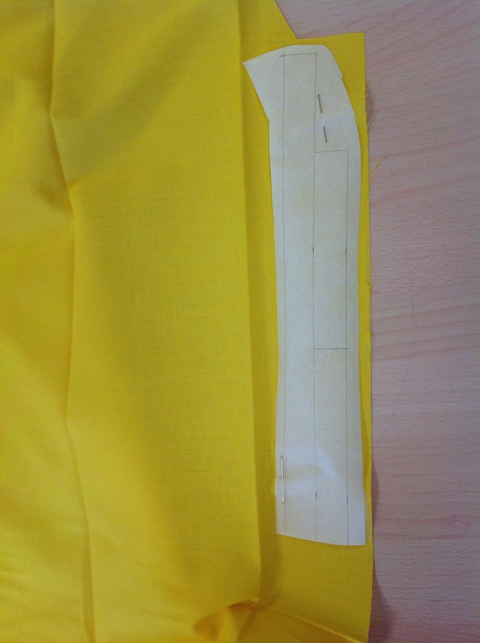 N\u00e5la fast vliesofixbiten p\u00e5 tyget med den knottriga sidan ner mot tyget och klipp ut strax utanf\u00f6r pappret.