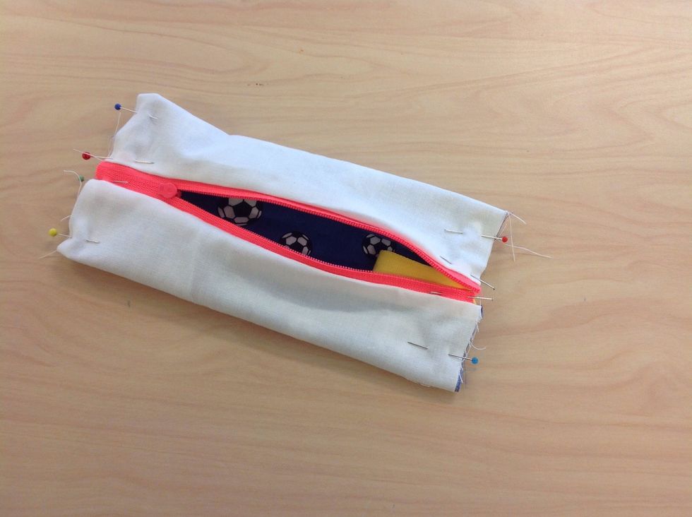 N\u00e5la ihop i b\u00e5da kortsidorna. L\u00e4gg i bandet om du vill ha ett. Sy raks\u00f6m, ta det lugnt \u00f6ver blixtl\u00e5set. Sicksacka sen kanterna.