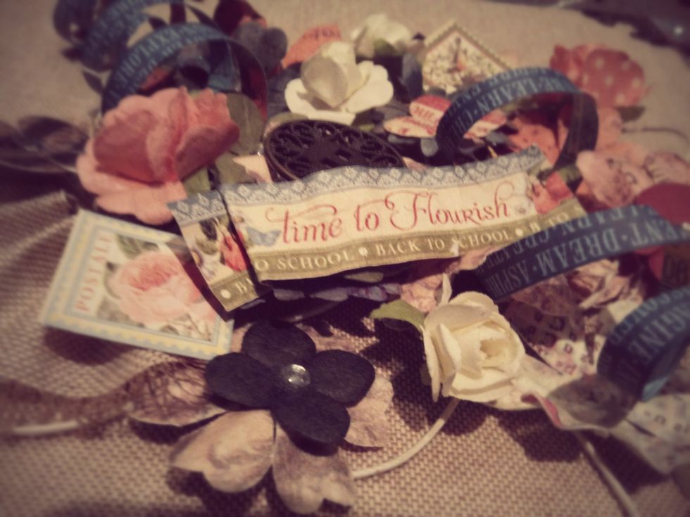 Na capa foram utilizadas flores decorativas da marca Prima (entre outras) bem como bot\u00f5es decorativos e outros acess\u00f3rios Tim Holtz.