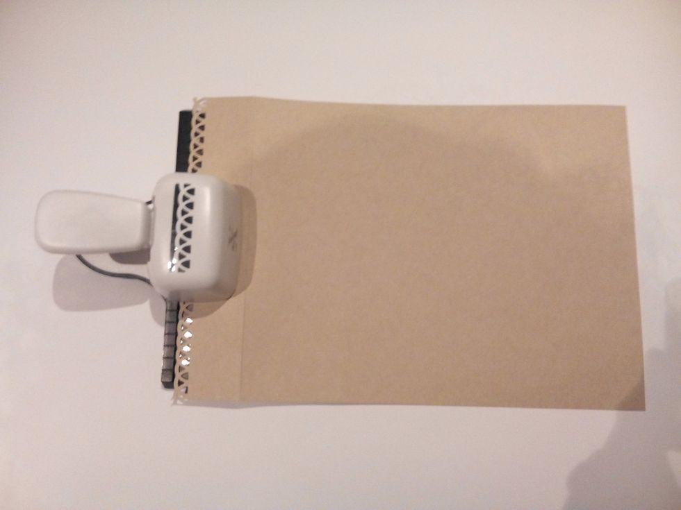Na lateral mais estreita das cartolinas maiores que servir\u00e3o de p\u00e1ginas do album, fure com um furador de friso. Aqui foi utilizado o Furador friso decorativo 4 cm La\u00e7o - Xcut.