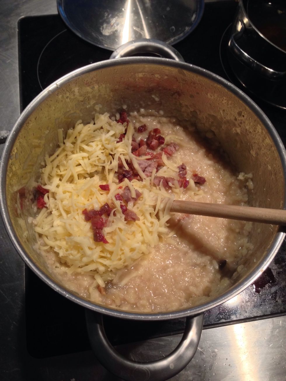 Nach 20 Minuten immer wieder mal probieren. Wenn gew\u00fcnschte Konsistenz erreicht ist, Speck, K\u00e4se, Pilze und Butter beigeben. Umr\u00fchren. Zudecken. Vom Herd nehmen.