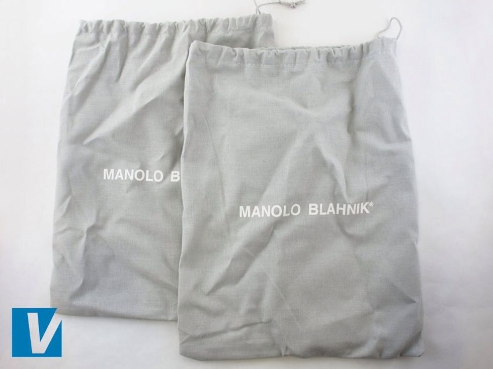 New Manolo Blahnik shoes are accompanied by a dust bag featuring the 'MANOLO BLAHNIK' logo across the centre. The registered trademark circled R is again also present.