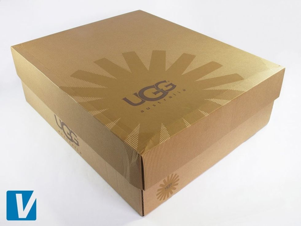 New Ugg boots are packaged in a sturdy, brown, 2 piece box featuring the starburst logo on the left corner of the lid, & on the side.