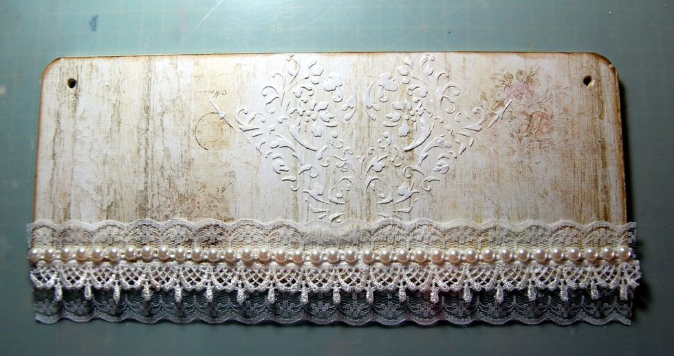 Next add a lace trim to the bottom edge. I layered two pieces of lace and then added a pearl trim on top.