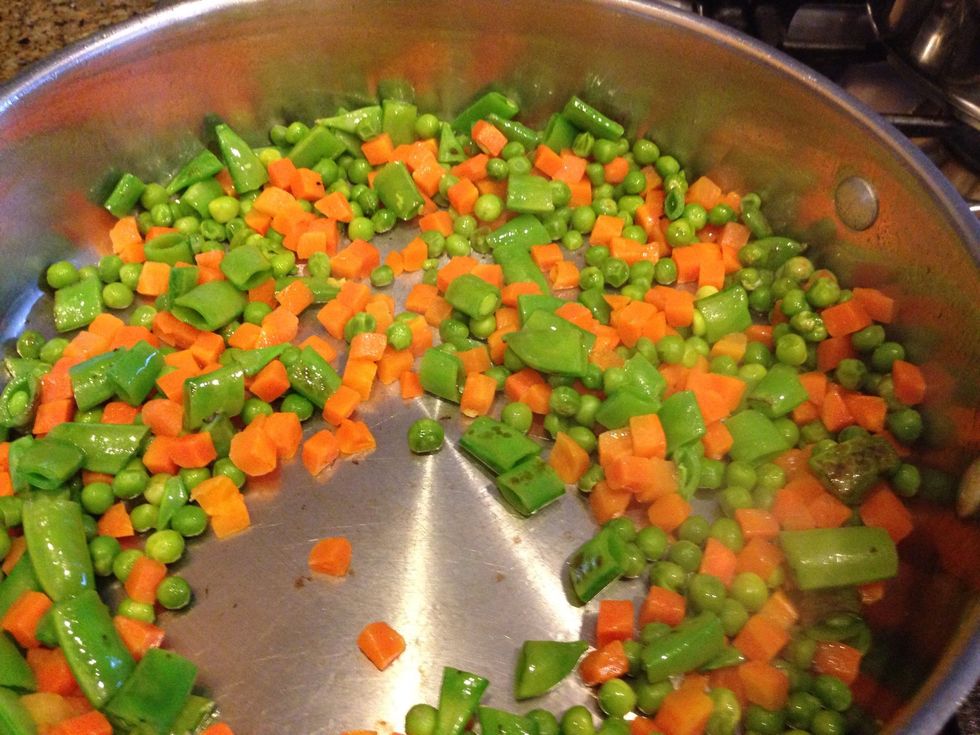 Next add fresh veggies such as the green onions and sugar snap peas and the frozen veggies (thawed) like carrots and peas. Cook in the pan for 5-7 min, stirring often.