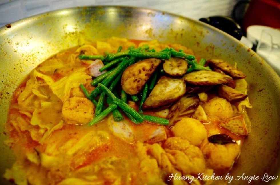 Next, add in the cooked brinjal, yam and long beans. Stir fry to combine everything together.