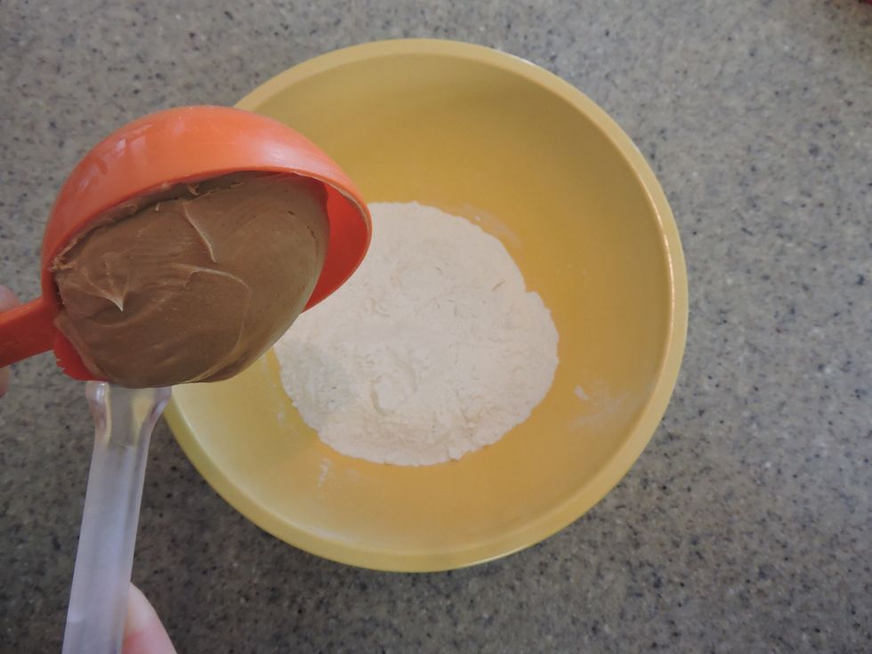 Next, add peanut butter to the large mixing bowl which contains the flour.