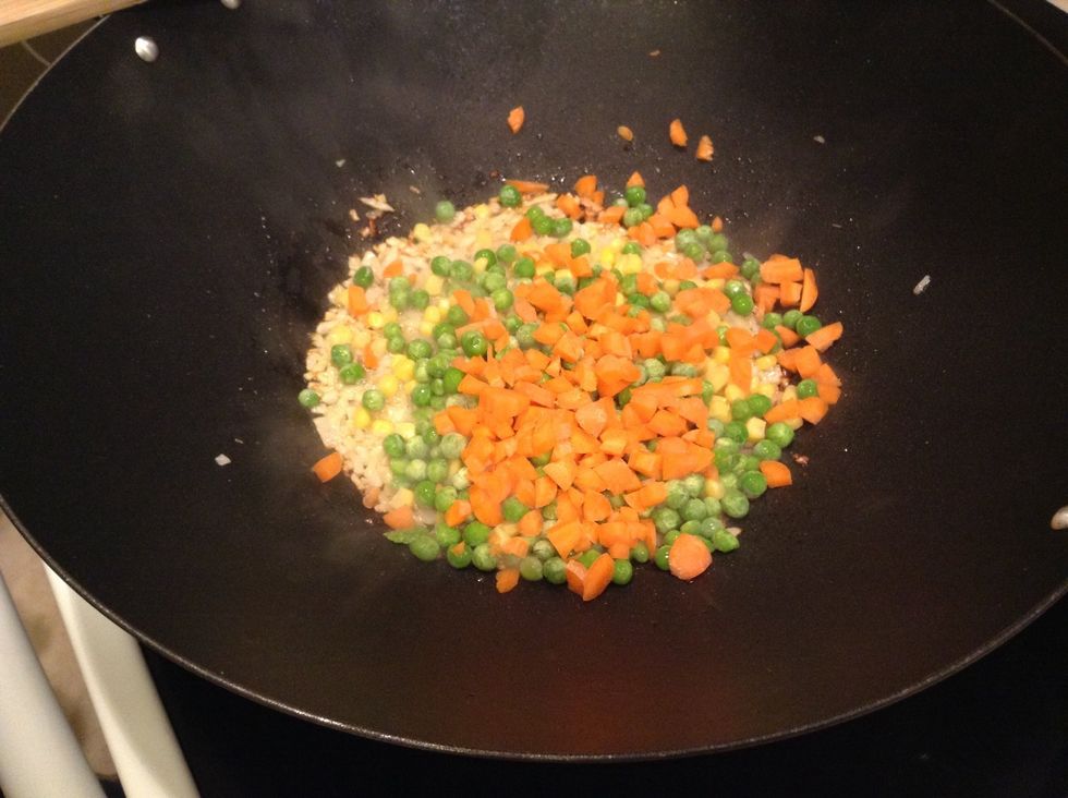 Next, add the corn, peas, and carrots. These take 3-4 minutes to cook, and remember to stir them! After a minute or so, add the sesame seeds