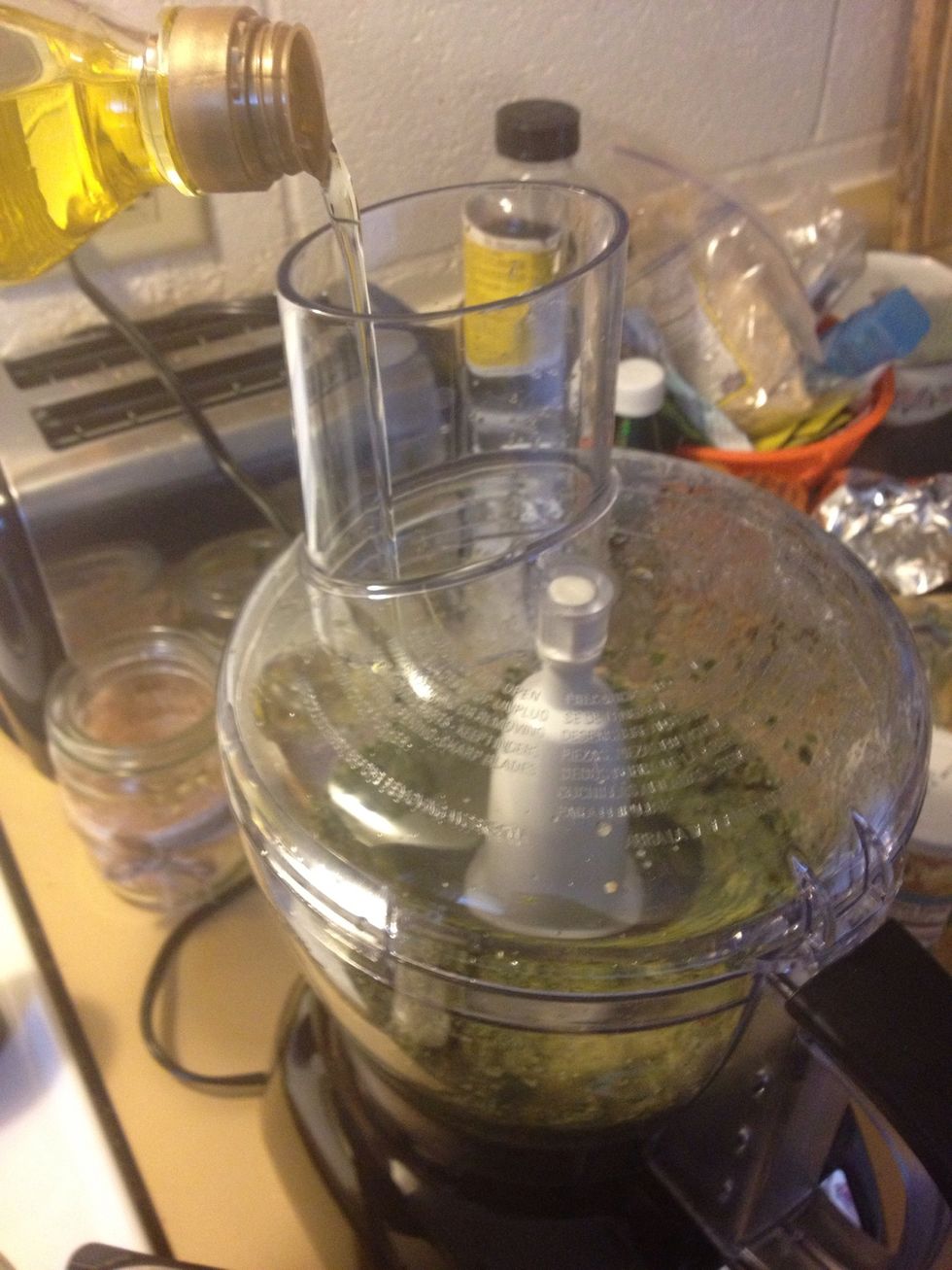 Next, add the olive oil, and while you're adding the oil continually pulse the processor (or blender) until everything is mixed together.