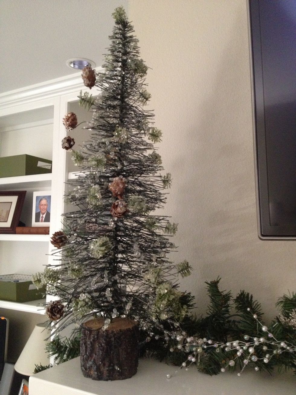 Next, add your tall decorations at the ends. I have these frosted trees from Michael's. You could use tall candelabras, snowmen, vases filled with ornaments, or other decorations to fit your theme.