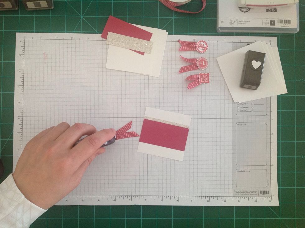 Next, apply some more adhesive to the back of the ribbon flag and punched image.