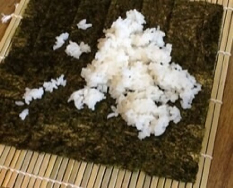 Next before you even start you need to have all your supplies out Then you take a piece  of nori and you pile rice on top and spread the rice on the nori but make sure you don't smear or els it'll rip
