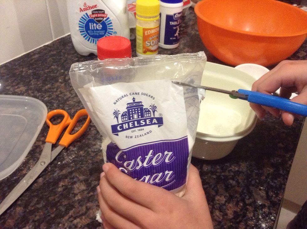 Next comes the castor sugar so we cut open the bag.