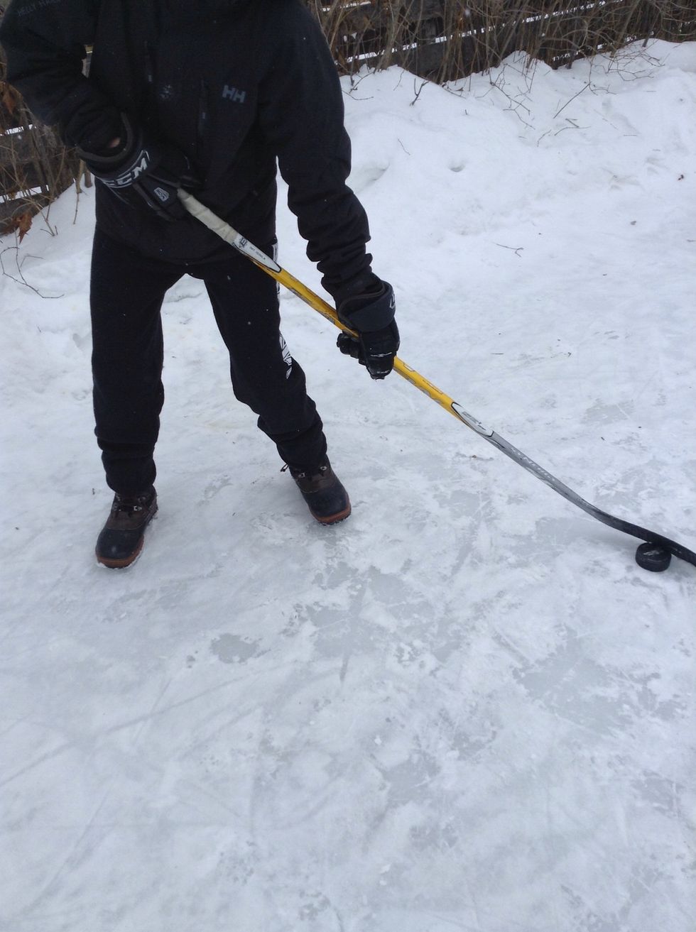 Next, cradle the puck backwards past your bent knees.