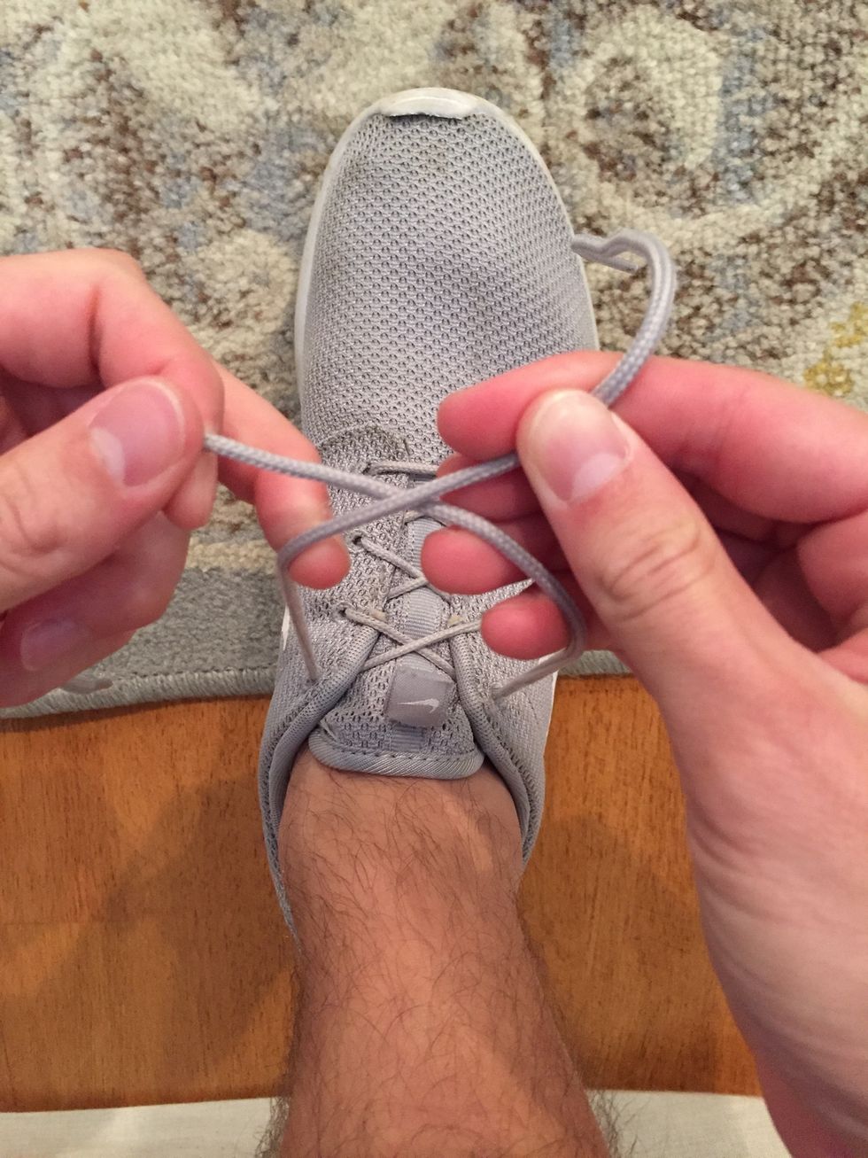 Next, cross over the laces while they are still tight, pulling directly toward you