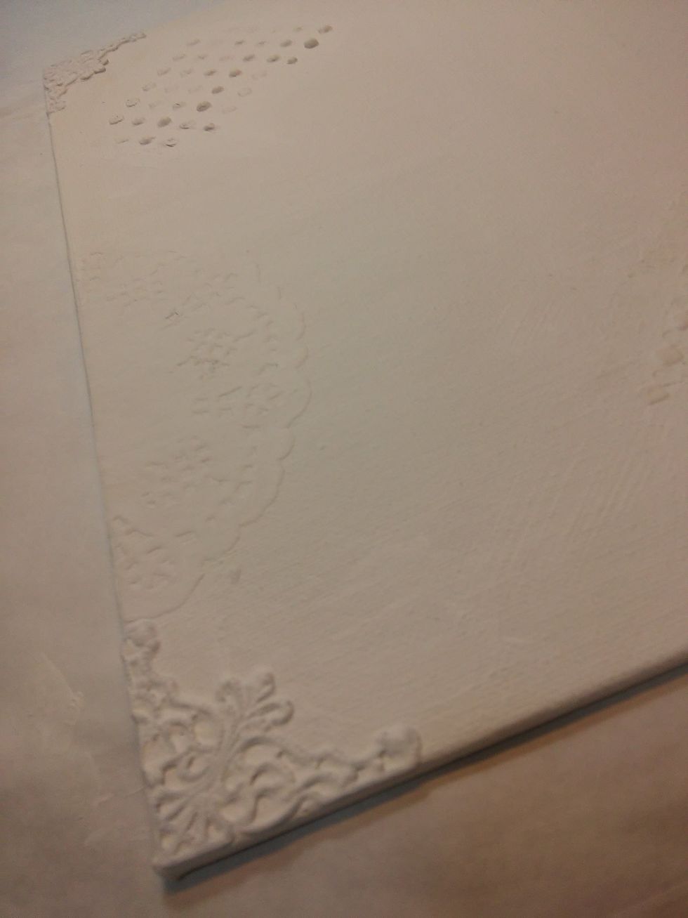 Next cut a paper doily in half and glued a piece to each side. Now I'll give everything a nice coat of gesso and dry it with my heat tool.