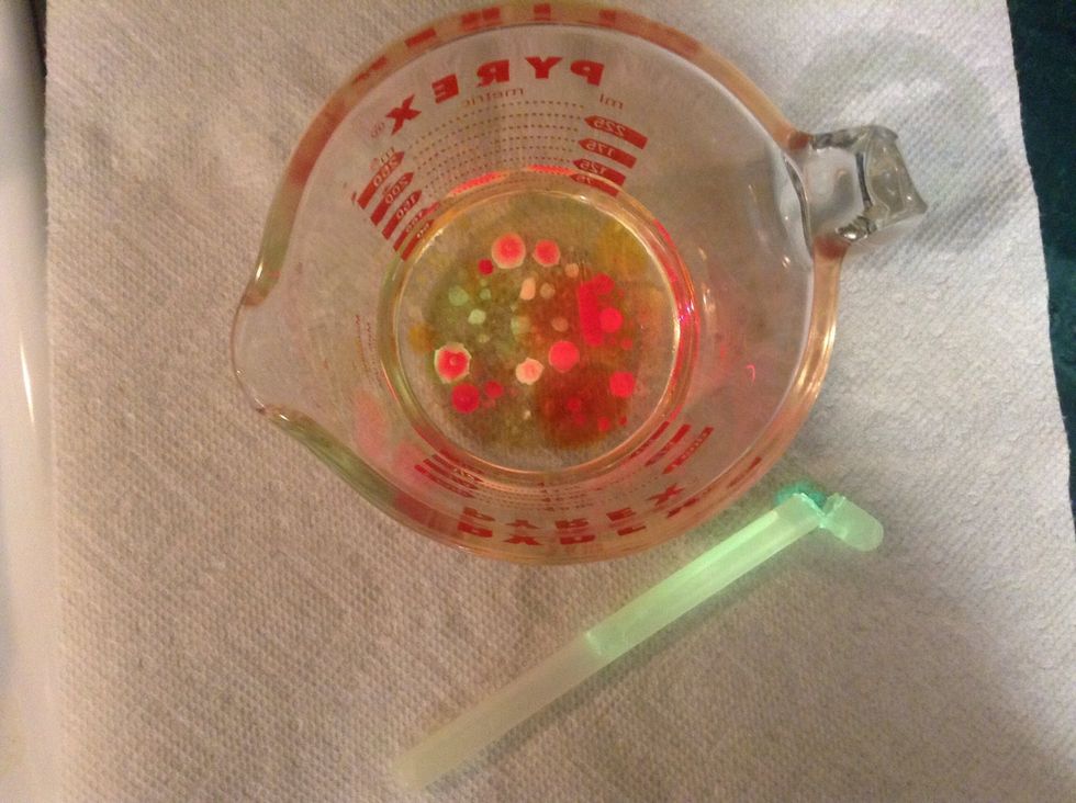 Next, cut the tip off of the one glow stick and pour the contents into the cup.