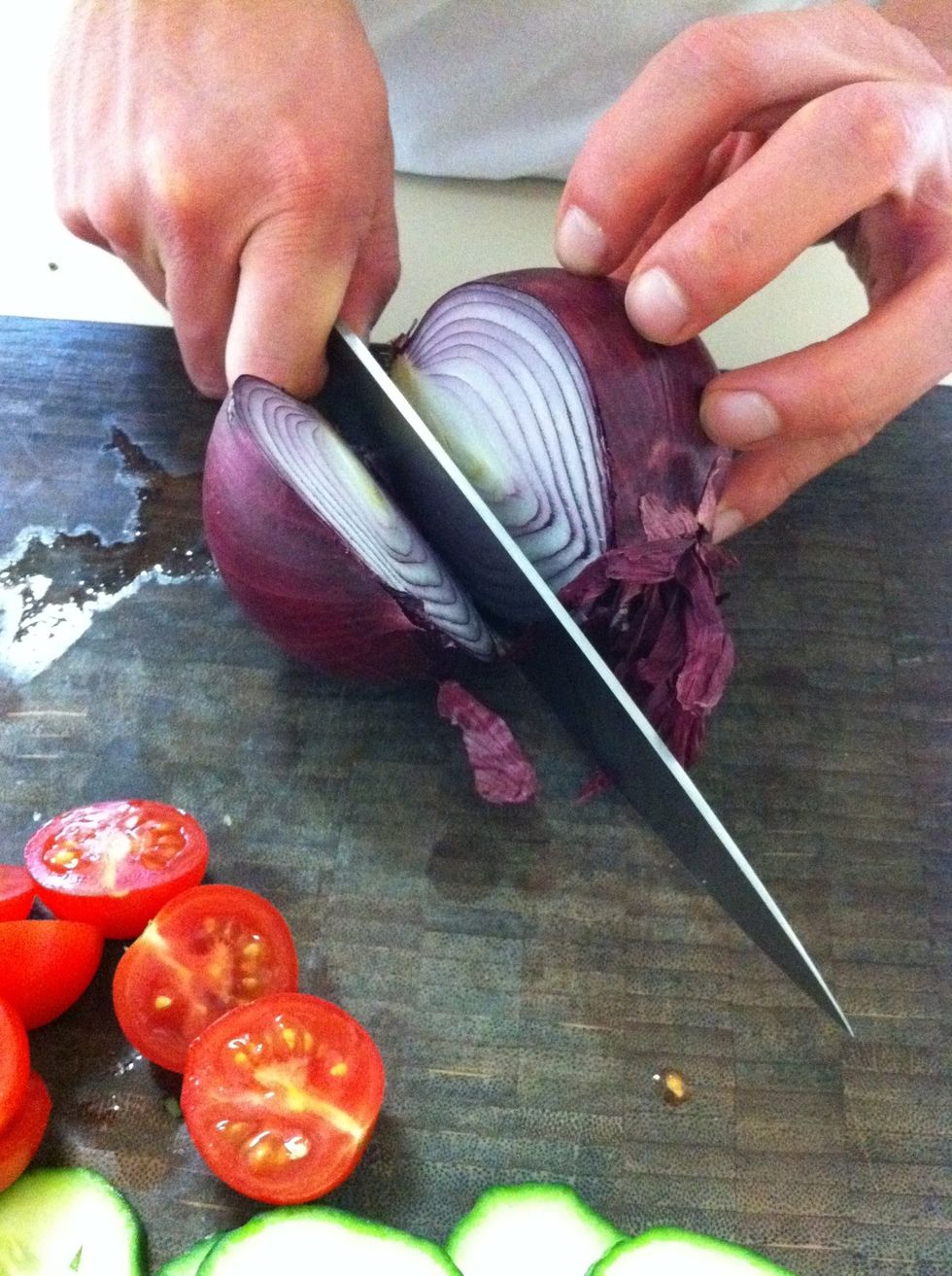 Next, cut the tip off your onion but be sure to leave the root on. Then cut your onion in half, right through the center of the root