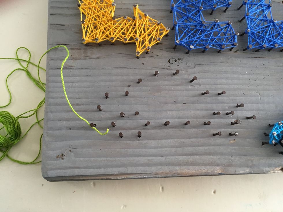 Next, Decide on the colors of craft twine (twisted embroidery floss) that you want to use. Once you've chosen, tie one end to a nail.