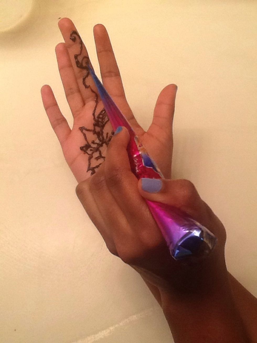 Next draw a curvy line coming from anywhere from the flower to the tip of your middle finger. Make little curves coming out from the line.