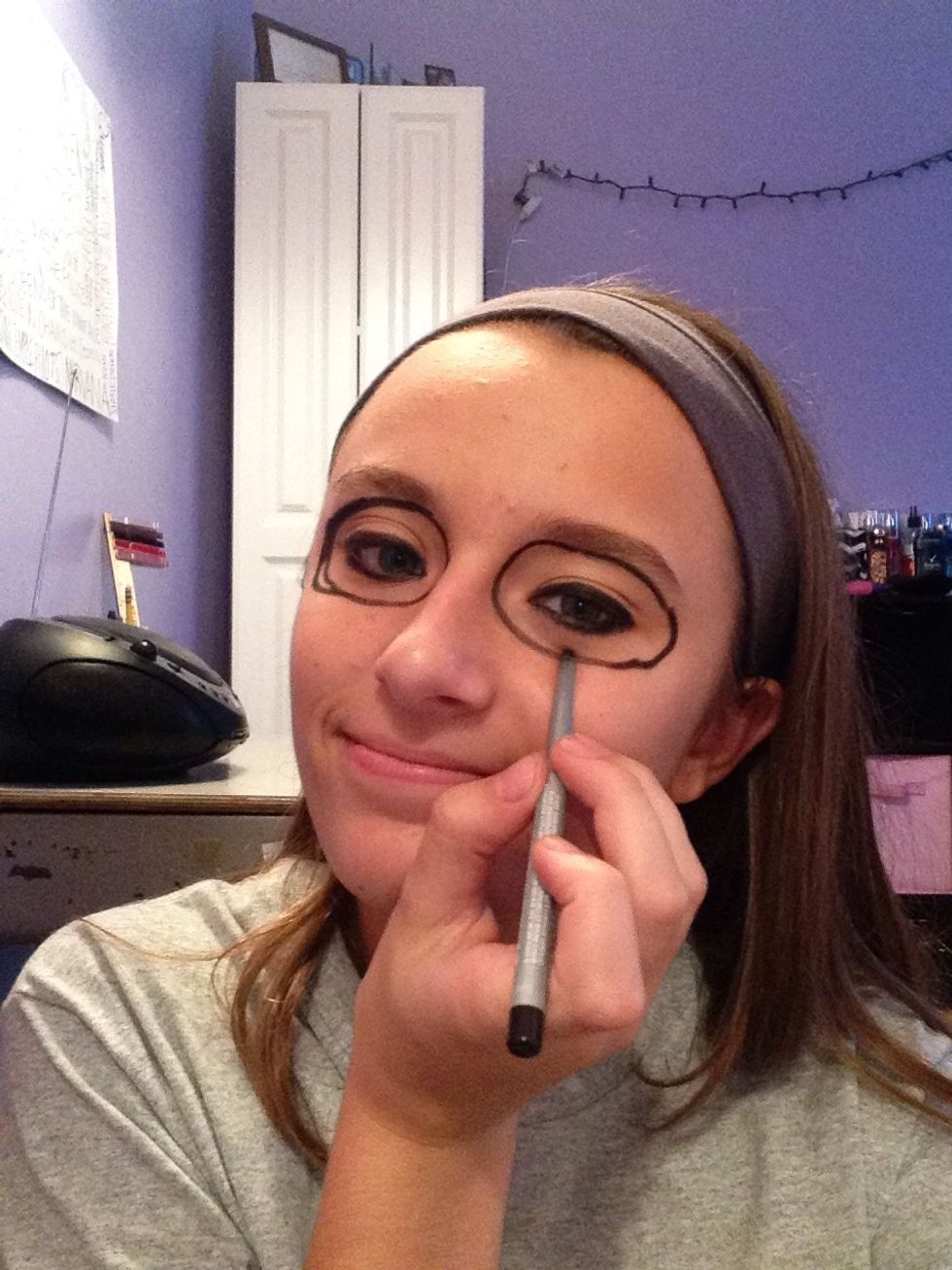 Next, draw circles around your eyes with black eyeliner