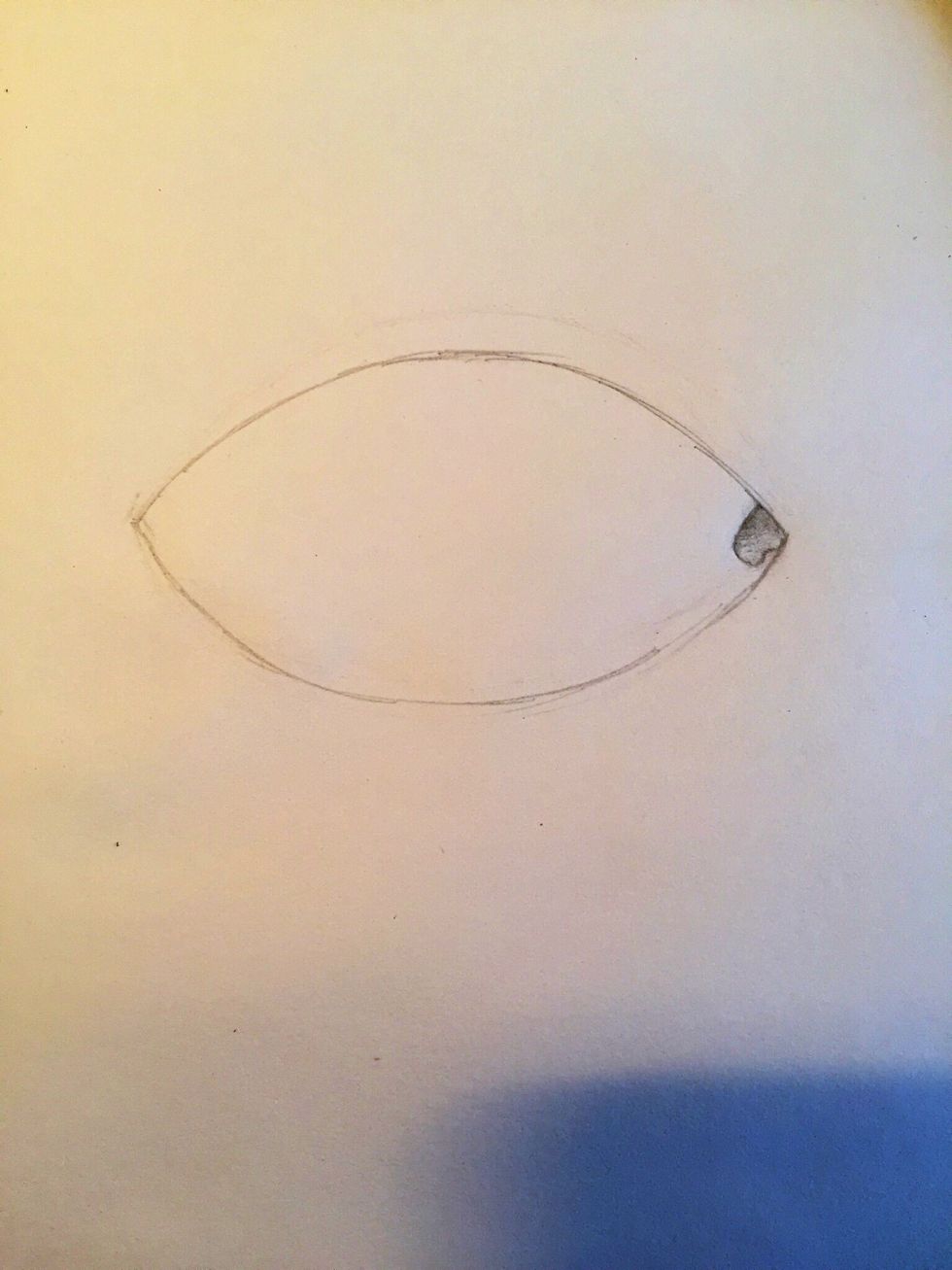 Next, draw the tear duct in the corner. This is an important detail that many people overlook. Shade it in so that it's lighter towards the bottom and darker towards the top, making it look curved.