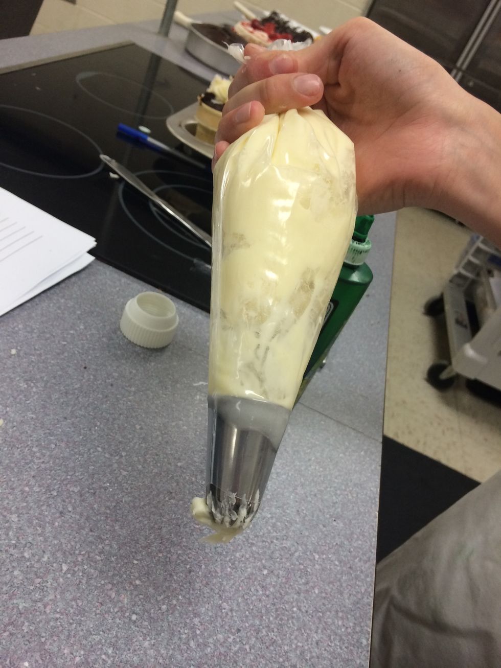 Next,fill a pastry bag with the buttercream. To make your life easier and less messy, fold over the top edge of the bag and spoon in, then unfold the top and there will be nothing around the top edge.