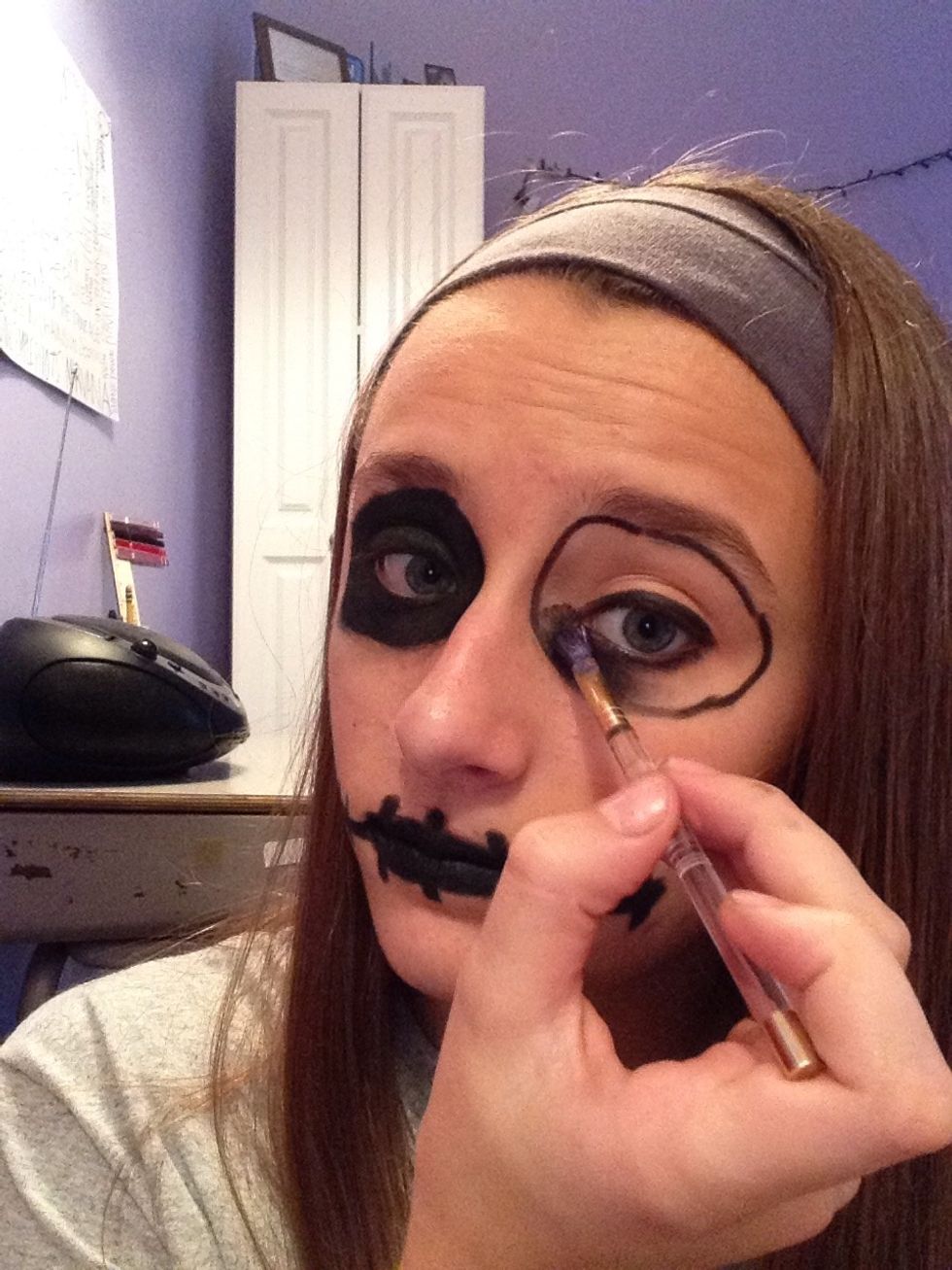 Next, fill in the circles around your eyes with black eyeshadow