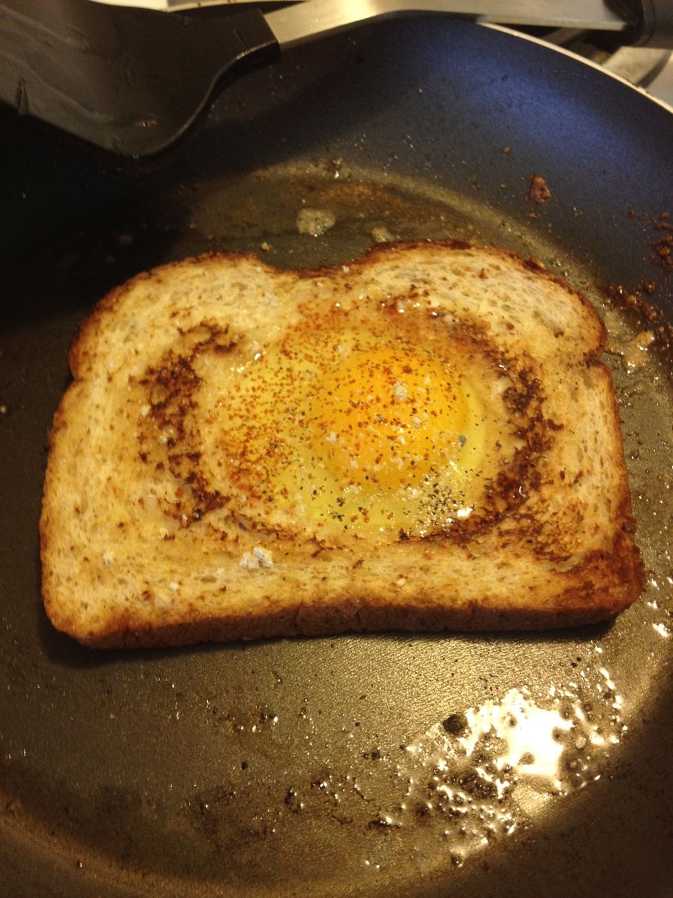 Next, flip your bread, add the egg, and add your desired seasoning (or just salt and pepper). Before you flip, wait for the whites to cook. You'll see it through the top, like how it's shown above.