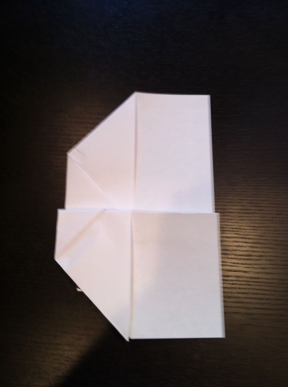 Next fold the left wing down leaving a small grab hold spot underneath it. Then fold the right wing to the same position.